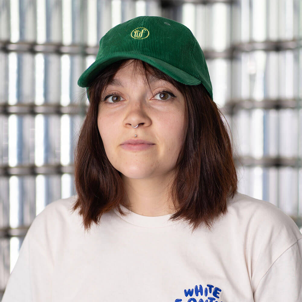 Casquette verte en velour brodé sur une femme avec percing