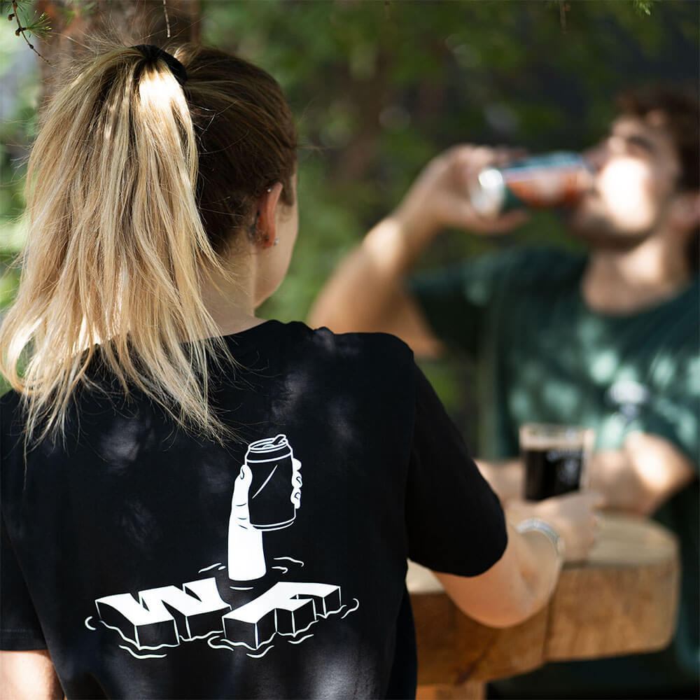 Femme de dos qui boit l'apéro avec t-shirt noir