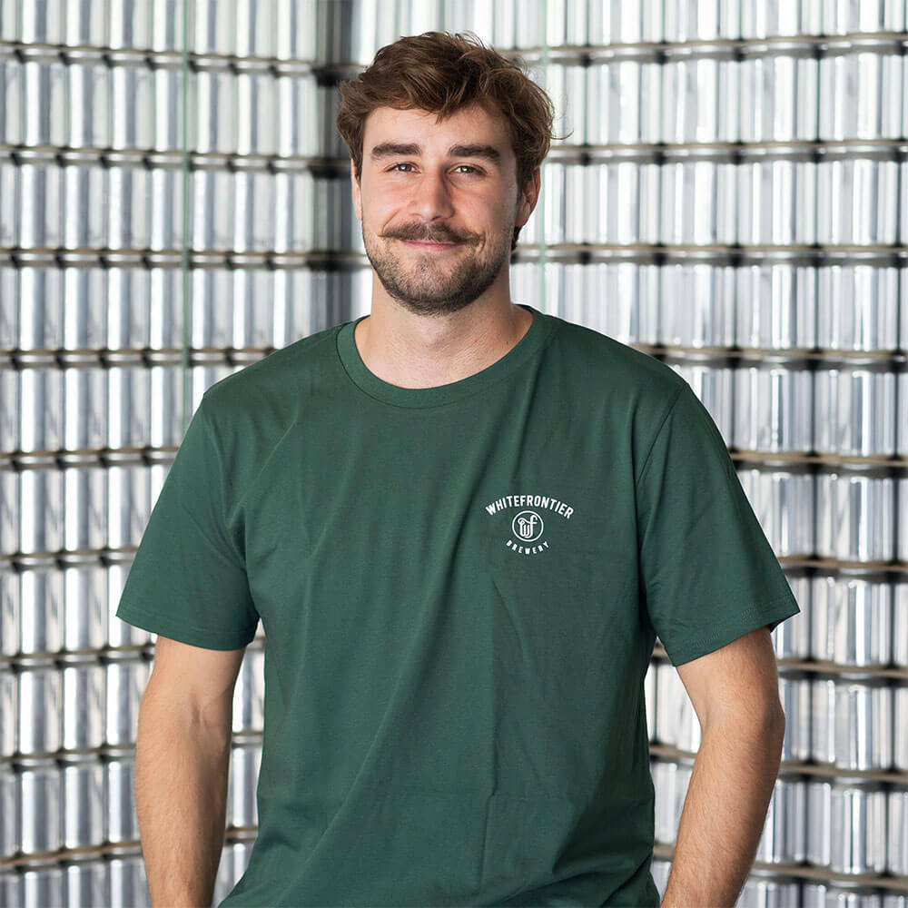 Homme souriant devant mûr de canette en aluminium