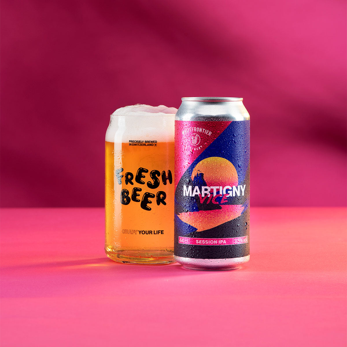 canette rose et bleu de martigny vice avec un verre de bière sur fond rose