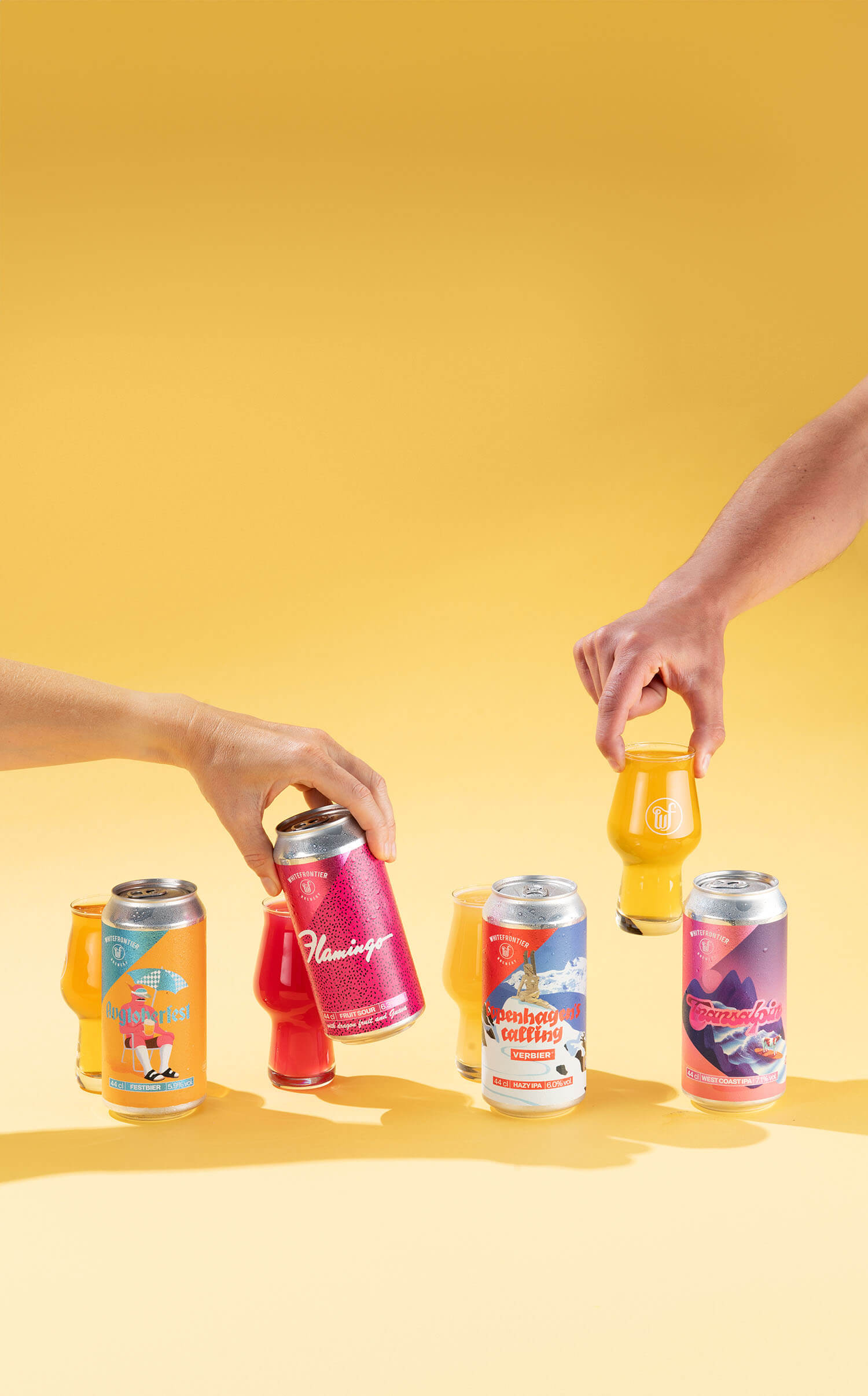 Canettes de bières en studio très coloré avec des bras. Fond jaune