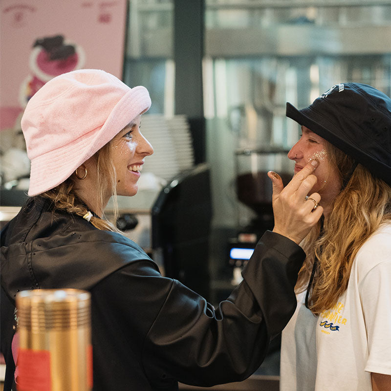 Deux femmes se mettend des paillettes sur les joues