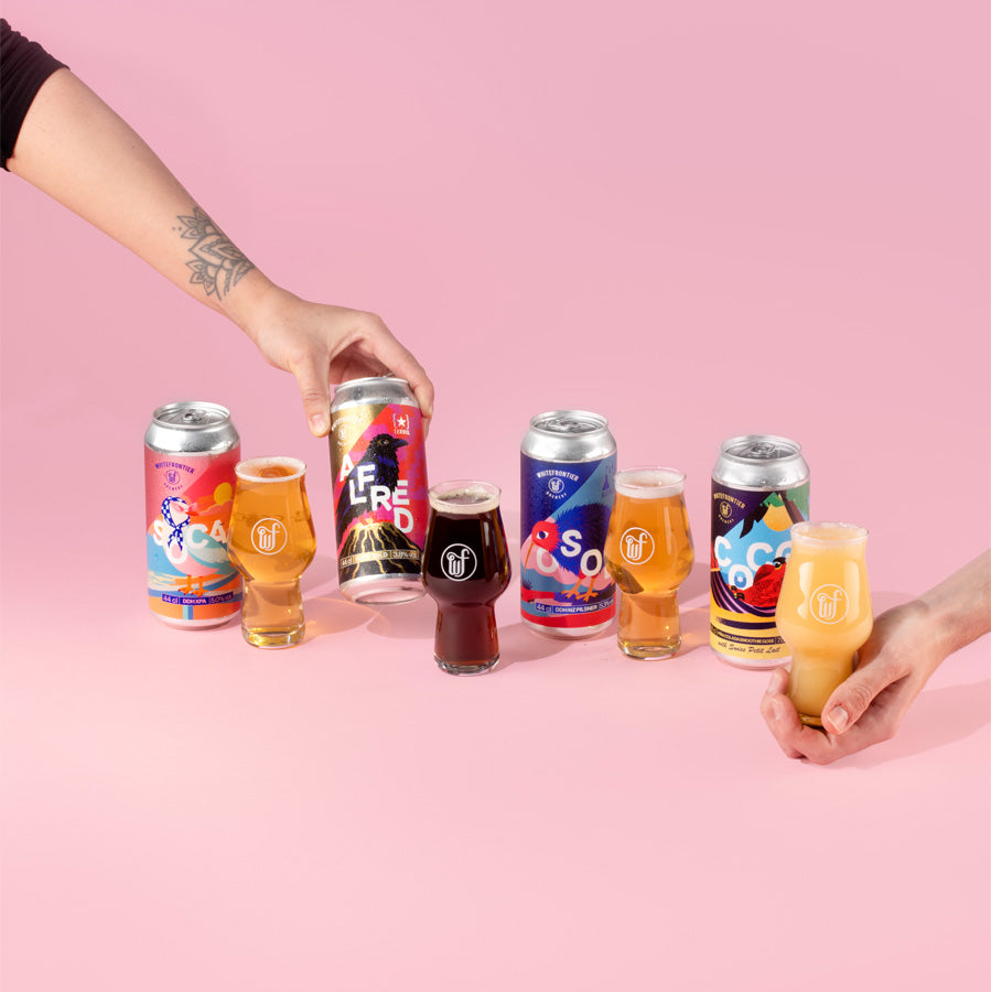 4 canettes de bières en studio sur fond rose