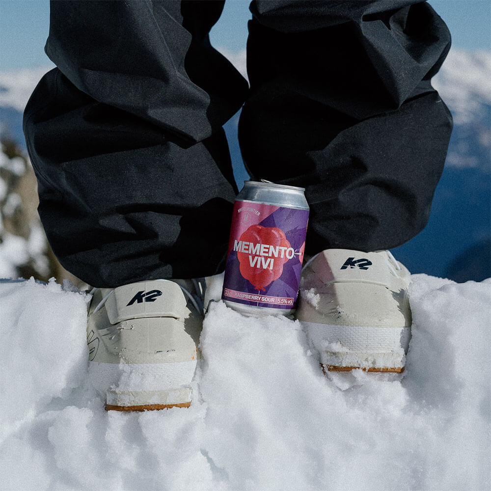 Une canette de bière entre deux chaussures de ski