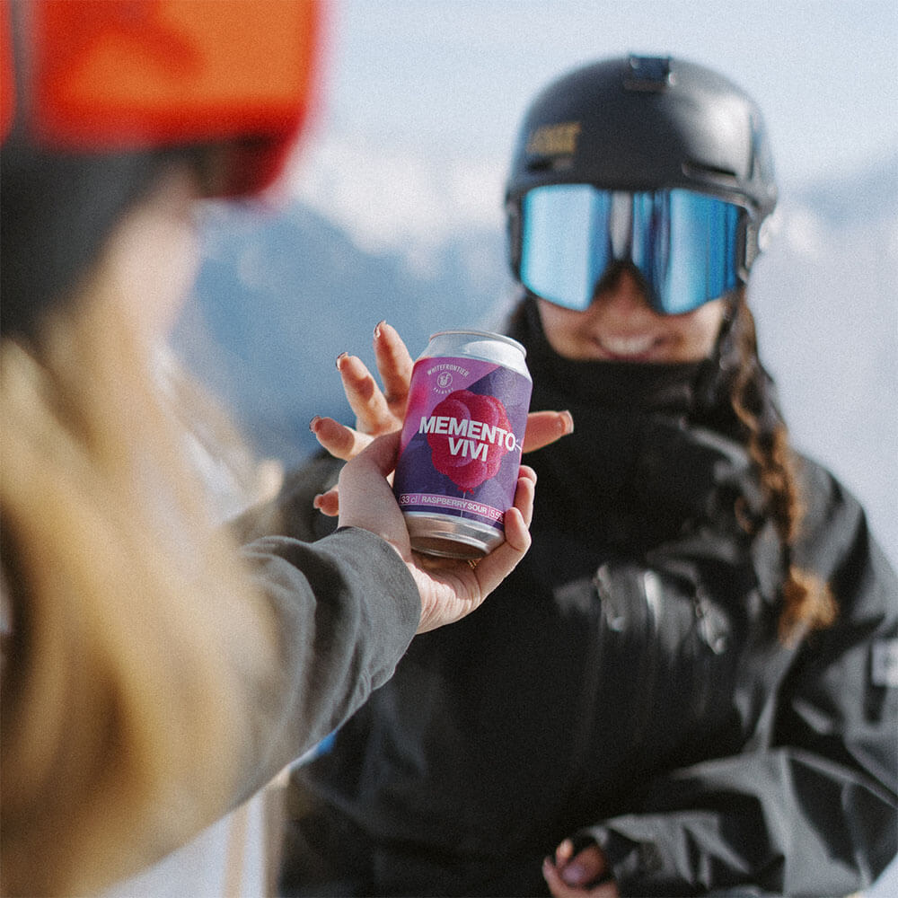 Une fille tend une bière à une autre fille