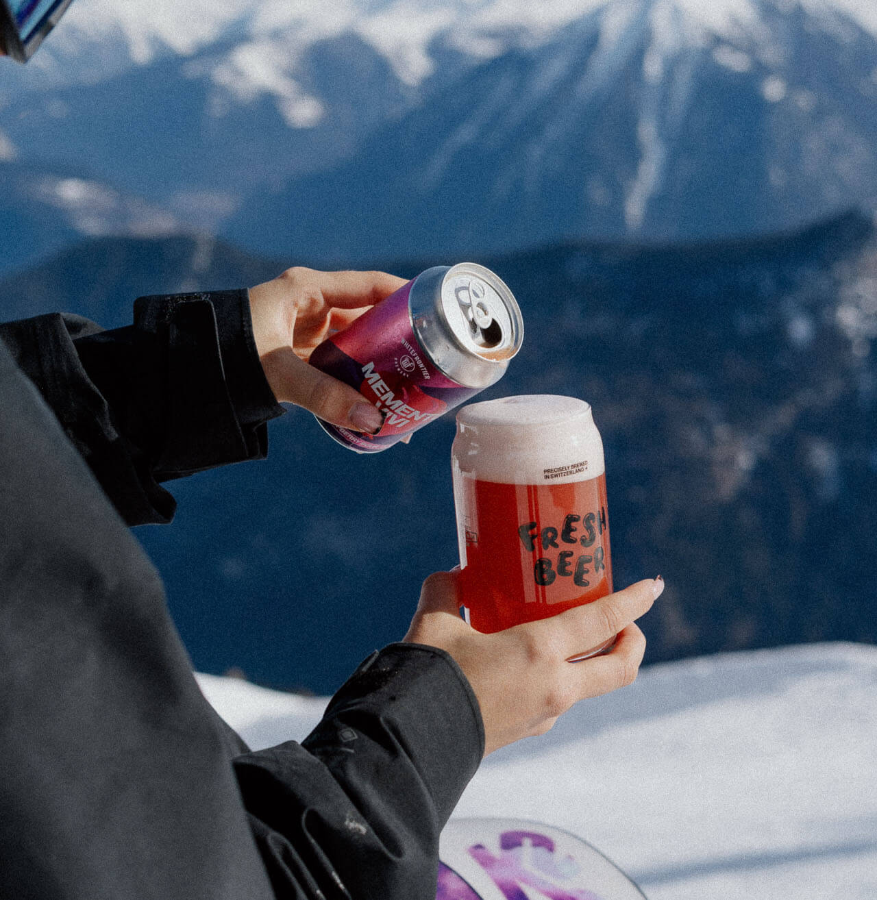 Une fille à la montagne verse une memento vivi dans un verre canette