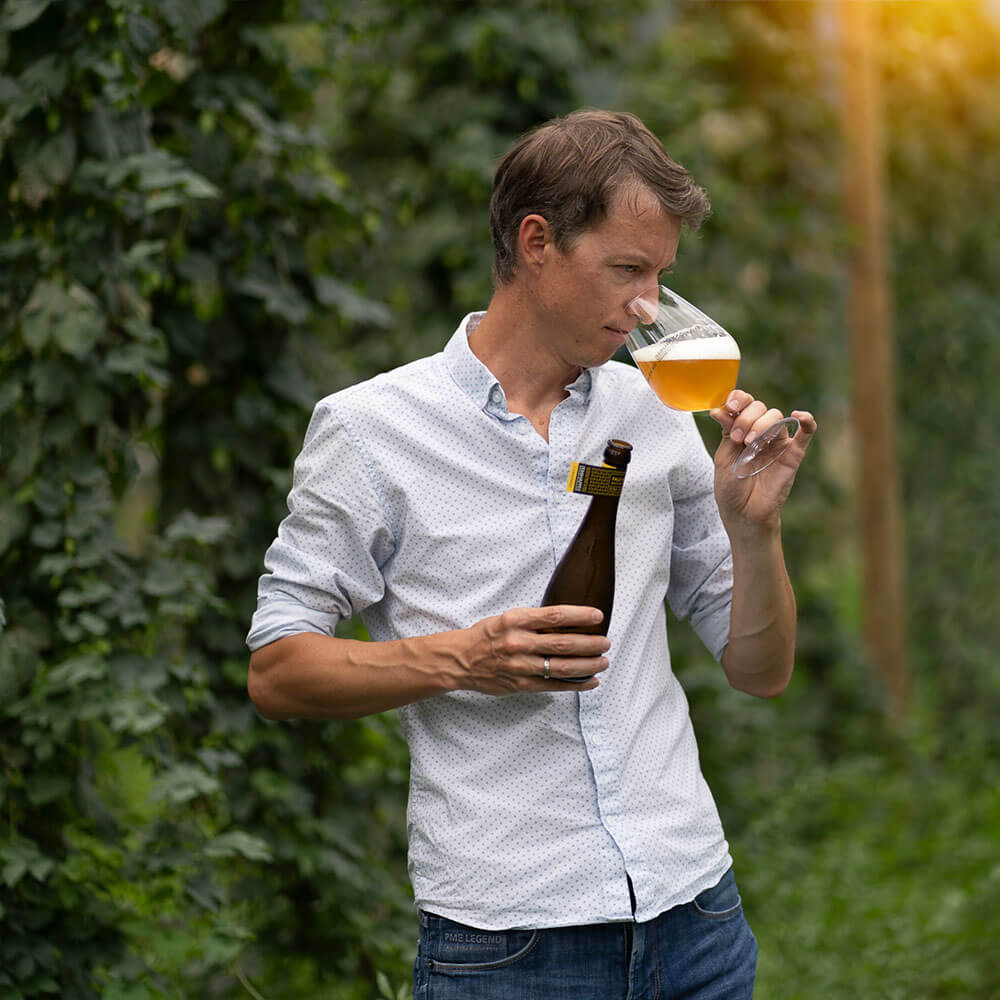 frederic rouvinez sent une bière dans un champs de houblon