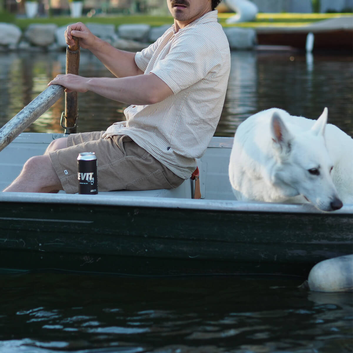 bière chien et humain dans une barque sur un lac
